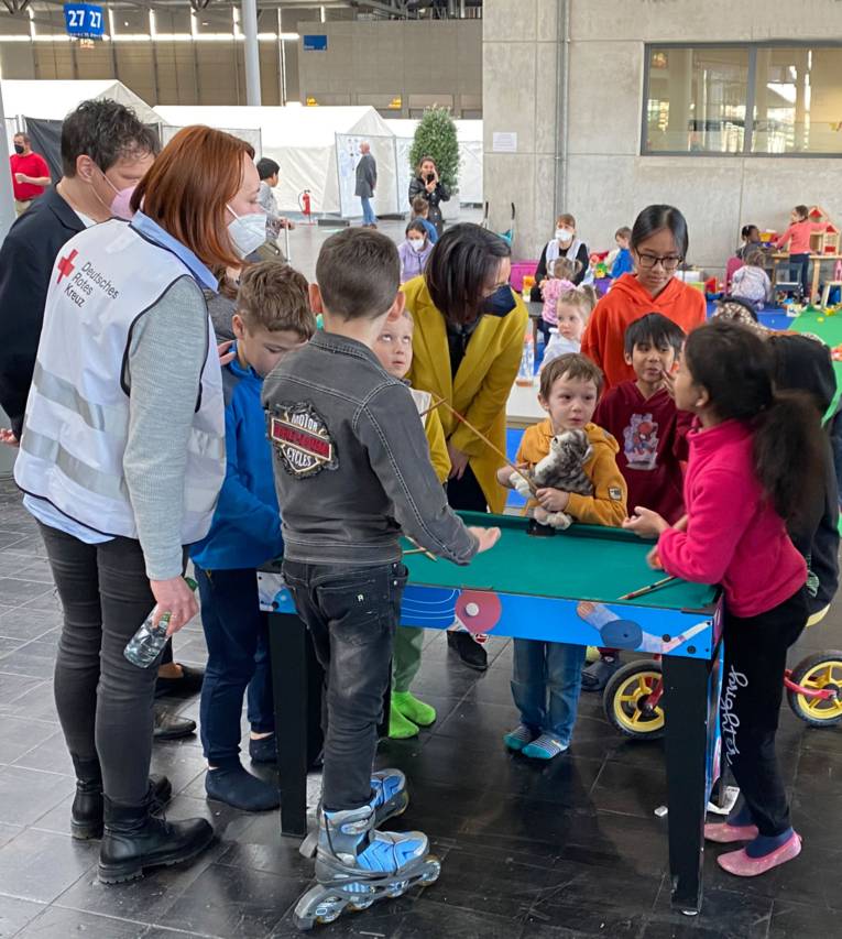 Erwachsene mit Kindern in der Flüchtlingsunterkunft Halle 27.